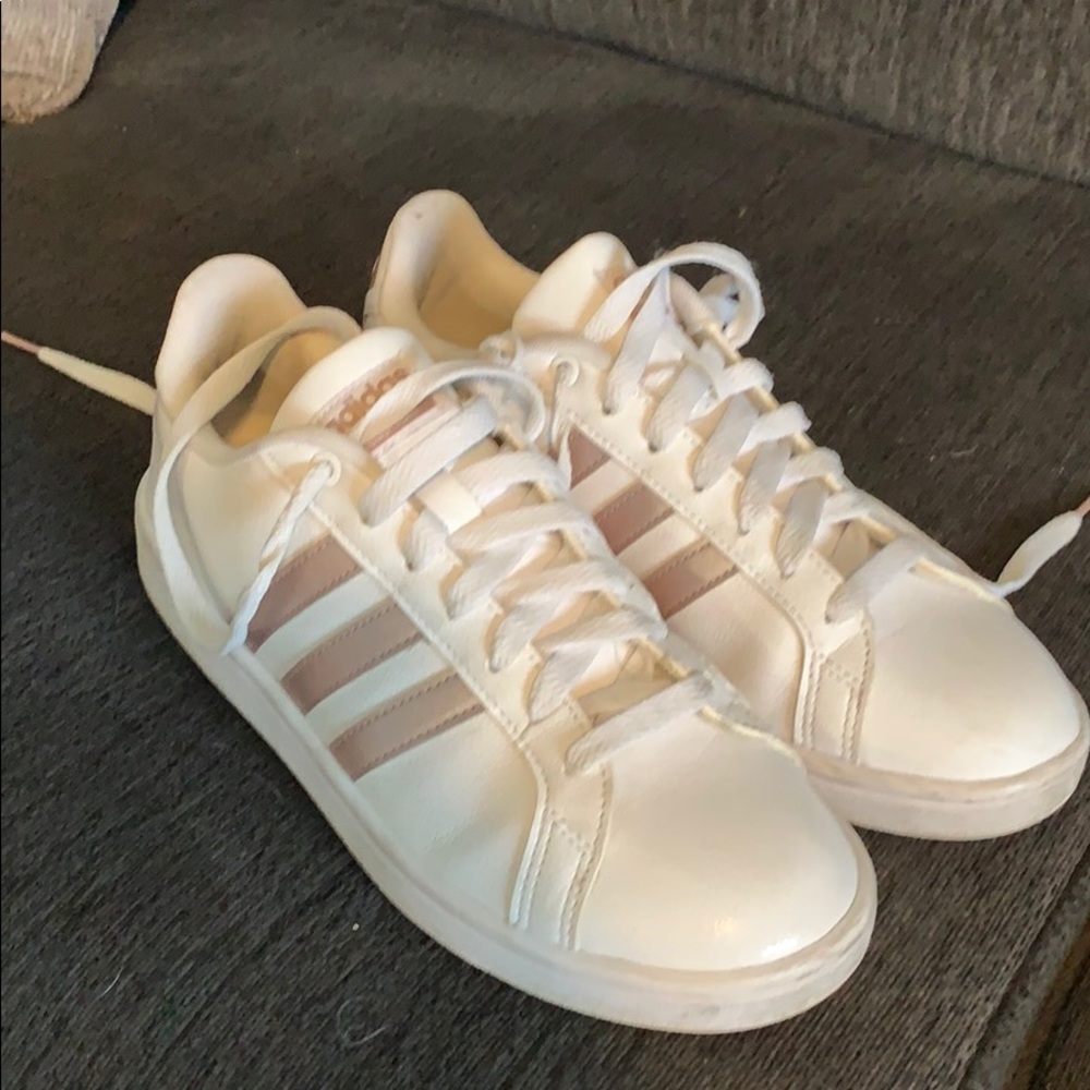 White and rose gold Adidas tennis shoes.